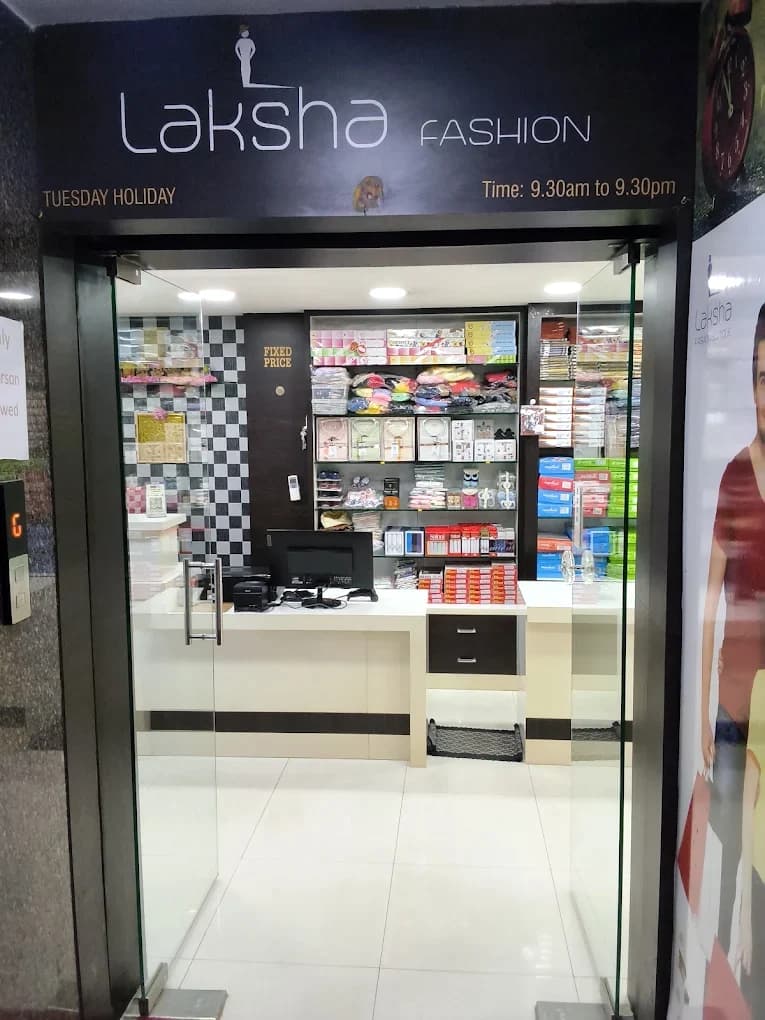 The Laksha Fashion entrance at MM Tower, Hosur: a black sign with white 'laksha FASHION' lettering above glass doors, with a bright white shop inside